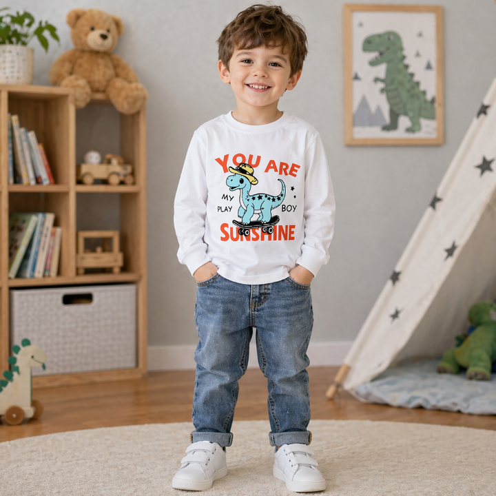 Child wearing a white dinosaur sweatshirt with a colorful sunshine graphic