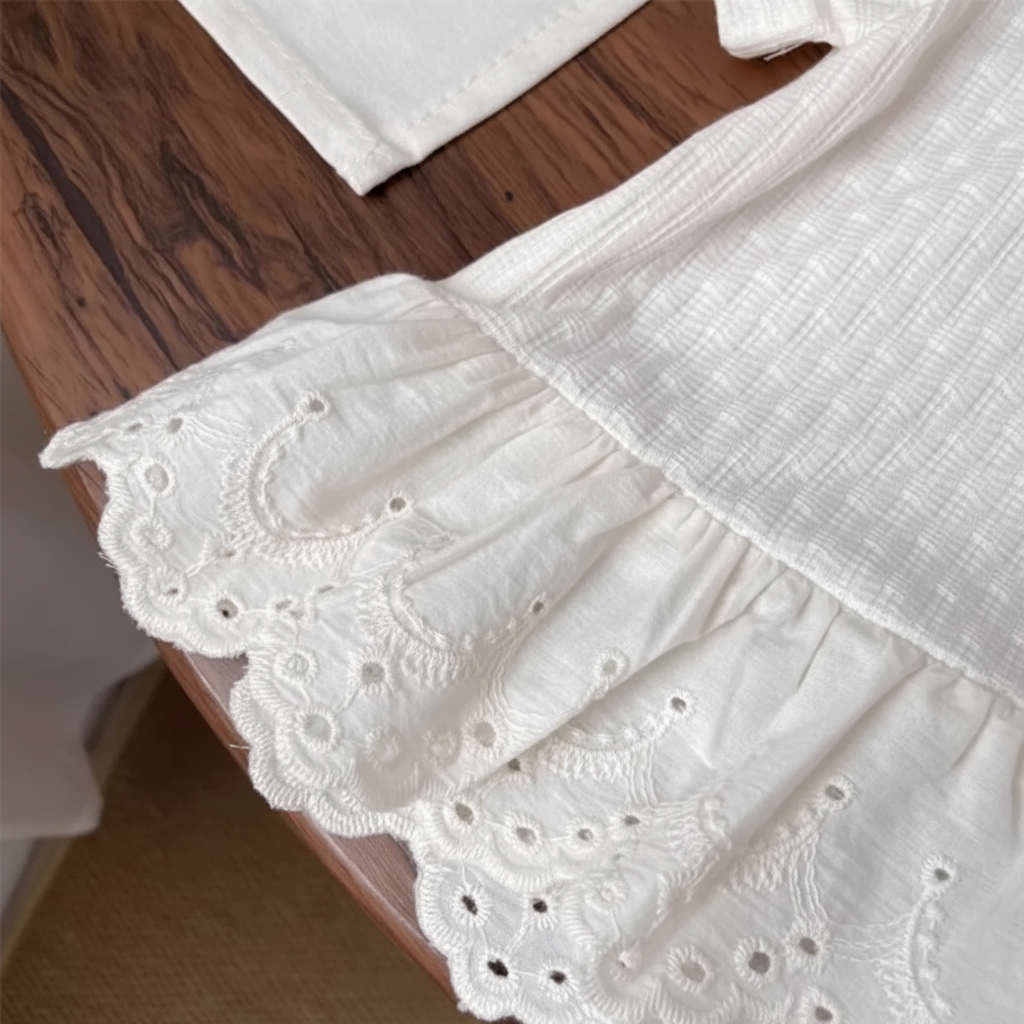 White T-shirt hem with gathered embroidered lace and a scalloped edge.