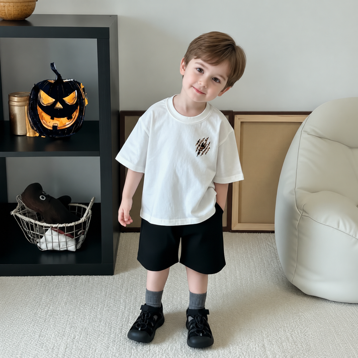Child wearing the white T-shirt with a small tiger chest graphic and black shorts.