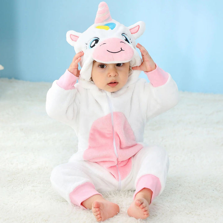 Baby wearing a white unicorn onesie with pink cuffs, a pink belly, and a horned hood