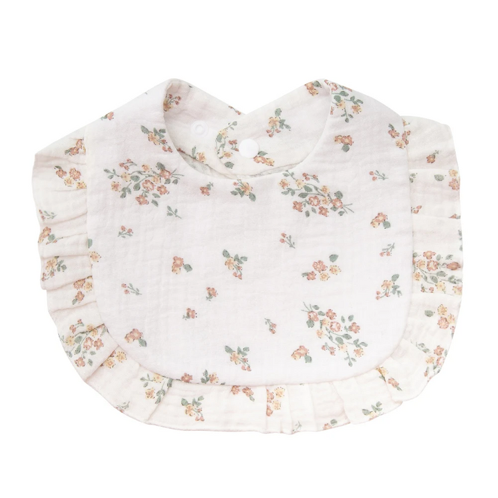 White cotton baby bib with scattered wildflower sprigs and ruffled trim