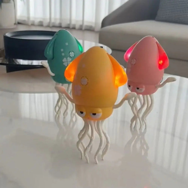 Pink, green, and yellow octopus toys with cream-colored tentacles on a table