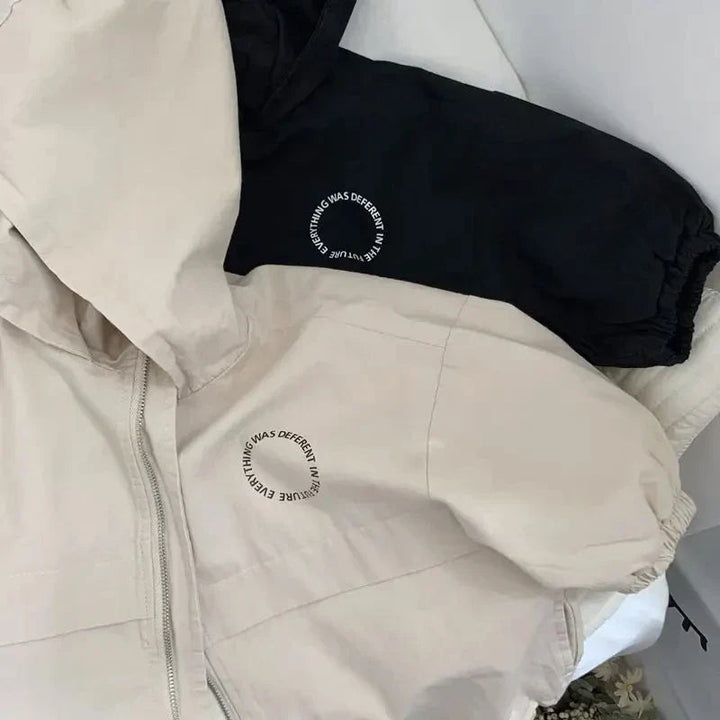 Beige and black jacket sleeves with elastic cuffs and small circular chest prints