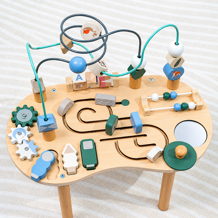 Wooden activity table viewed from above with bead maze, gears, sliding tracks, and counting beads