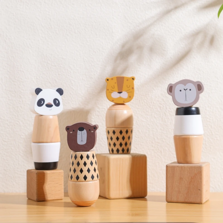 Four wooden animal stacking toys arranged among wooden display blocks