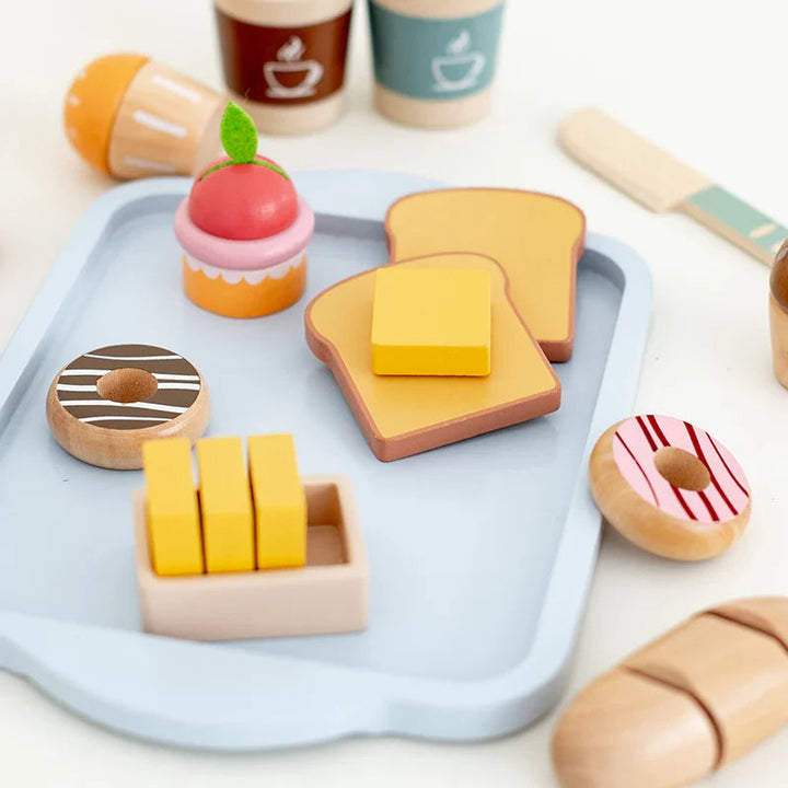Wooden toast, butter, doughnuts, and a cupcake arranged on a blue breakfast tray