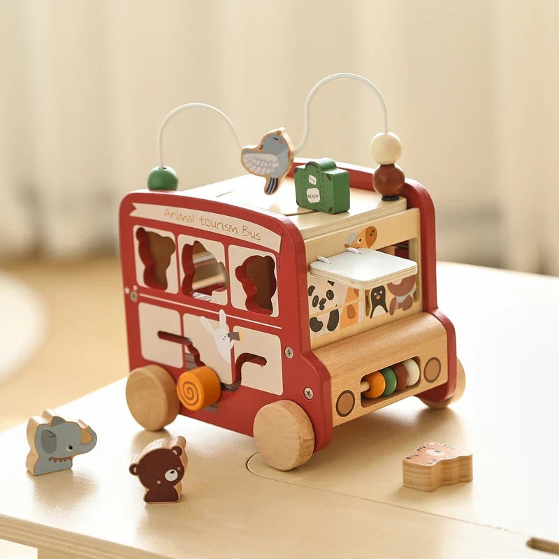 Red wooden activity bus showing the animal sorter, rotating puzzle, and side abacus