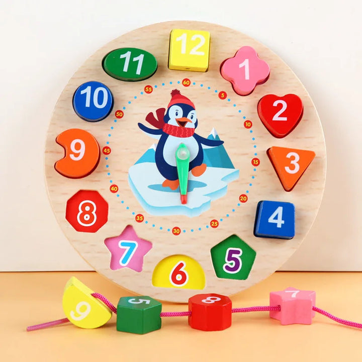 Wooden teaching clock with colorful number blocks and several blocks threaded onto a pink lace