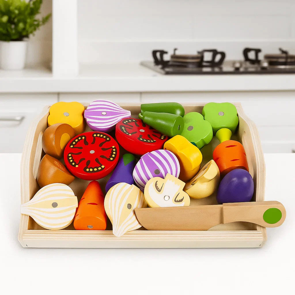 Tray of wooden vegetable pieces with onion halves, tomato slices, and a wooden toy knife