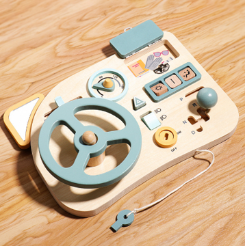 Wooden steering wheel activity board with an open hinged panel and tethered key on a wood surface
