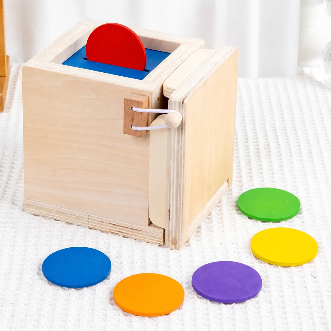 Red coin in the slot of a wooden drop box, with colorful round coins beside it
