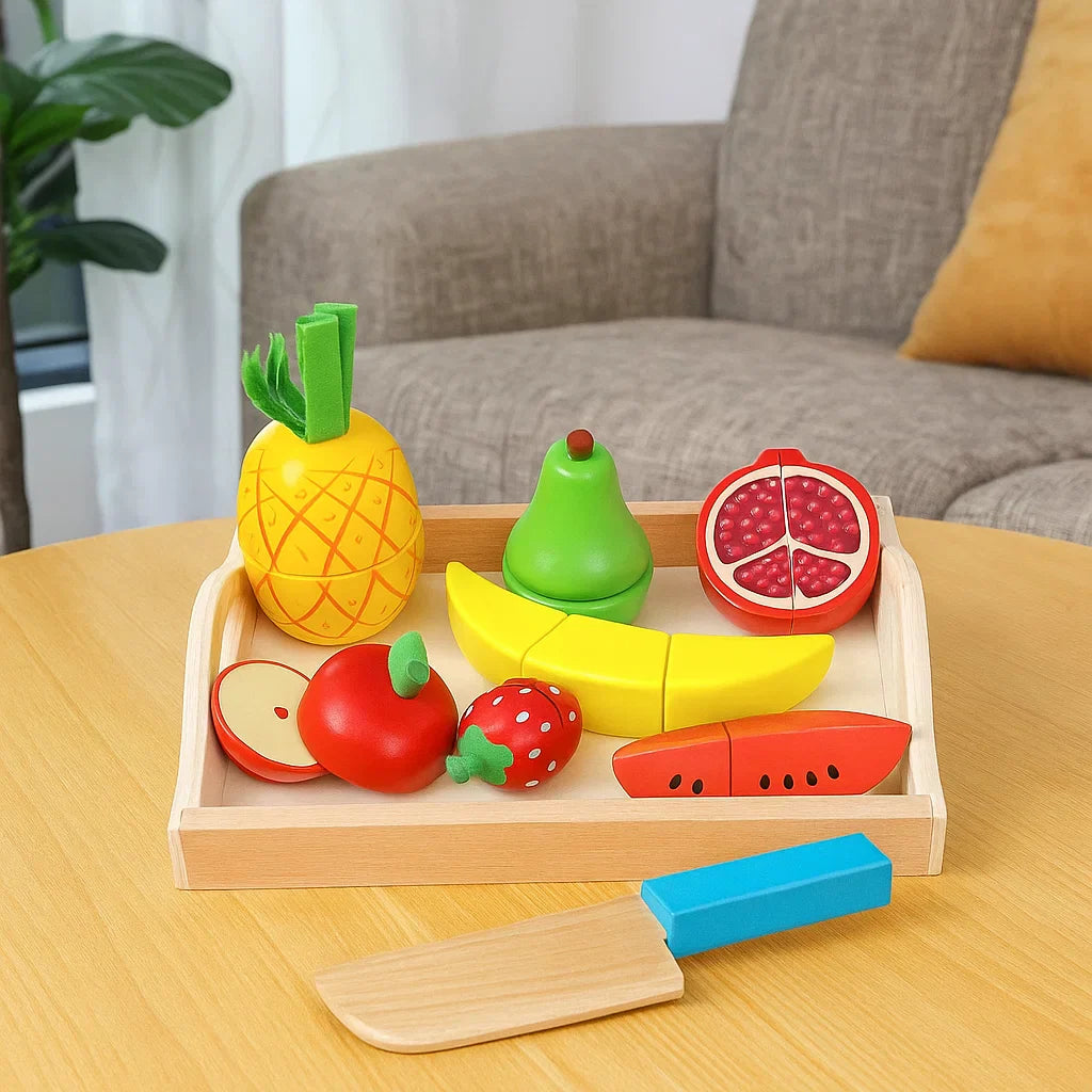Wooden fruit play food with pineapple, pear, banana, watermelon, and a toy knife beside the tray
