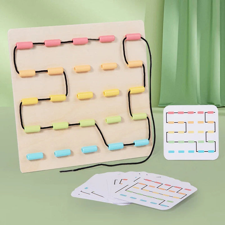 Wooden lacing board with a winding black cord, pastel guides, and illustrated pattern cards.