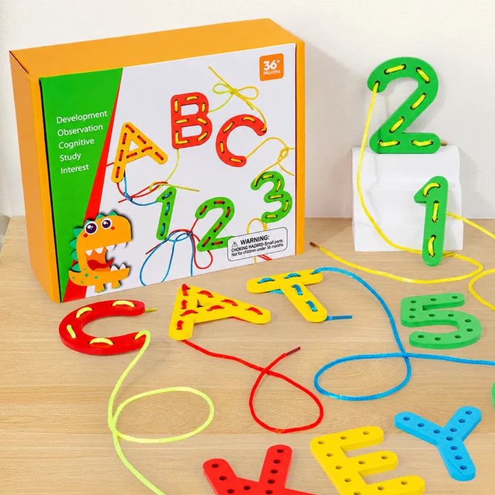 Colorful wooden letter and number lacing pieces with cords beside the box