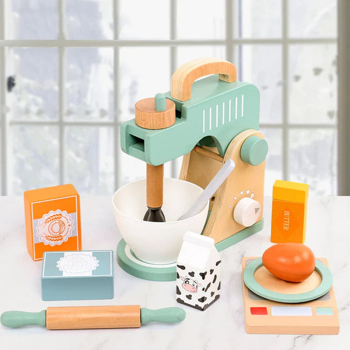 Wooden mixer play set arranged on a counter with a bowl, rolling pin, play scale, and pretend ingredients