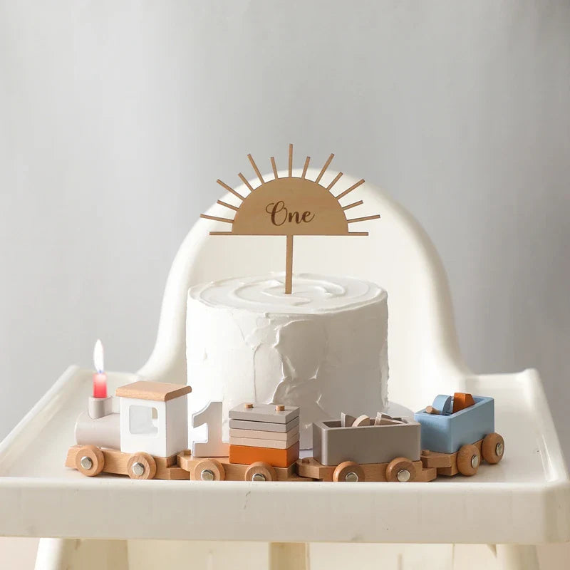Wooden number train with a number one beside a birthday cake