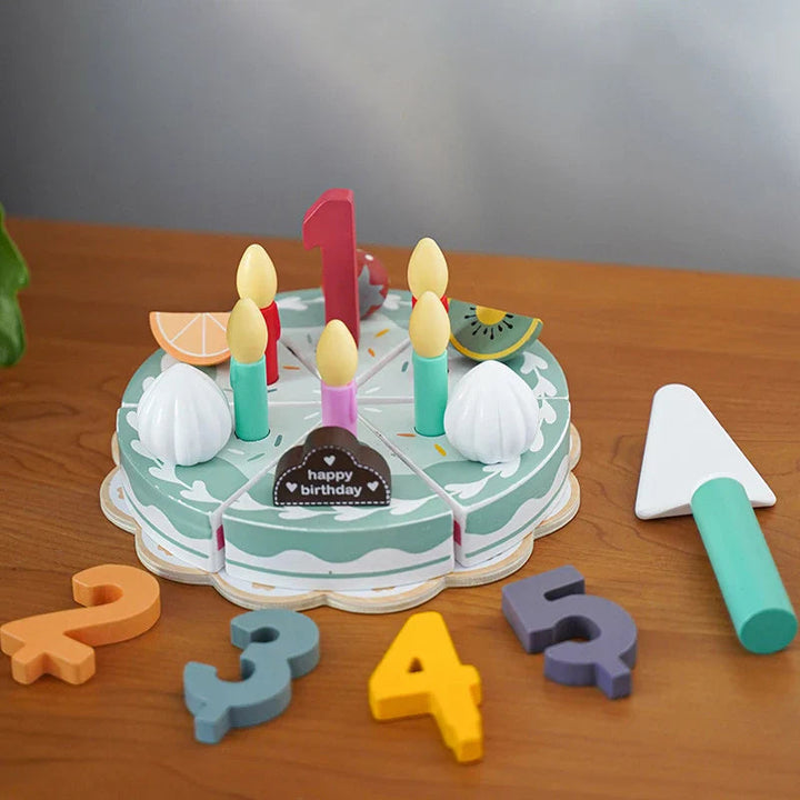 Wooden birthday cake on a tray with number decorations and a green-handled toy slicer