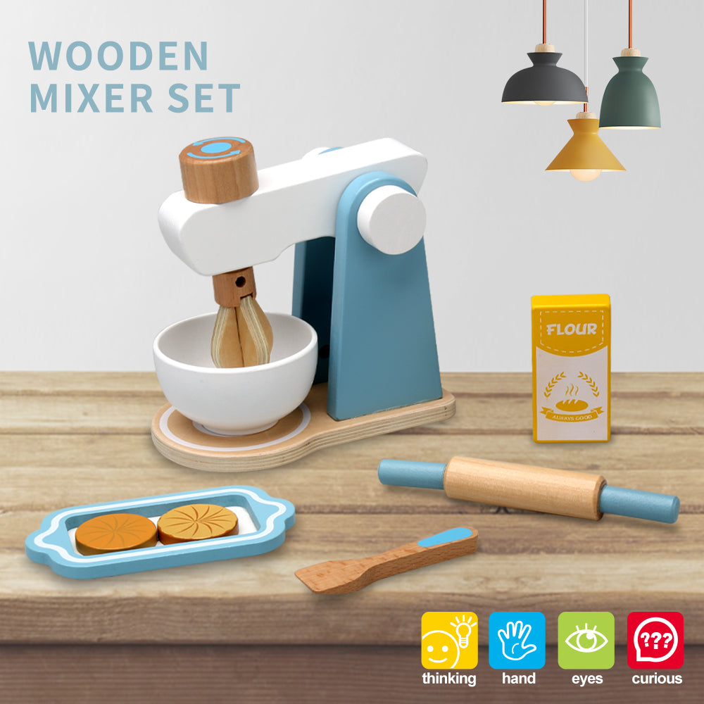 Blue-and-white wooden play mixer with bowl, rolling pin, spoon, flour carton, and cookie tray on a tabletop
