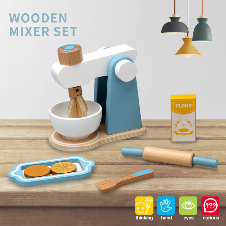 Blue-and-white wooden play mixer with bowl, rolling pin, spoon, flour carton, and cookie tray on a tabletop