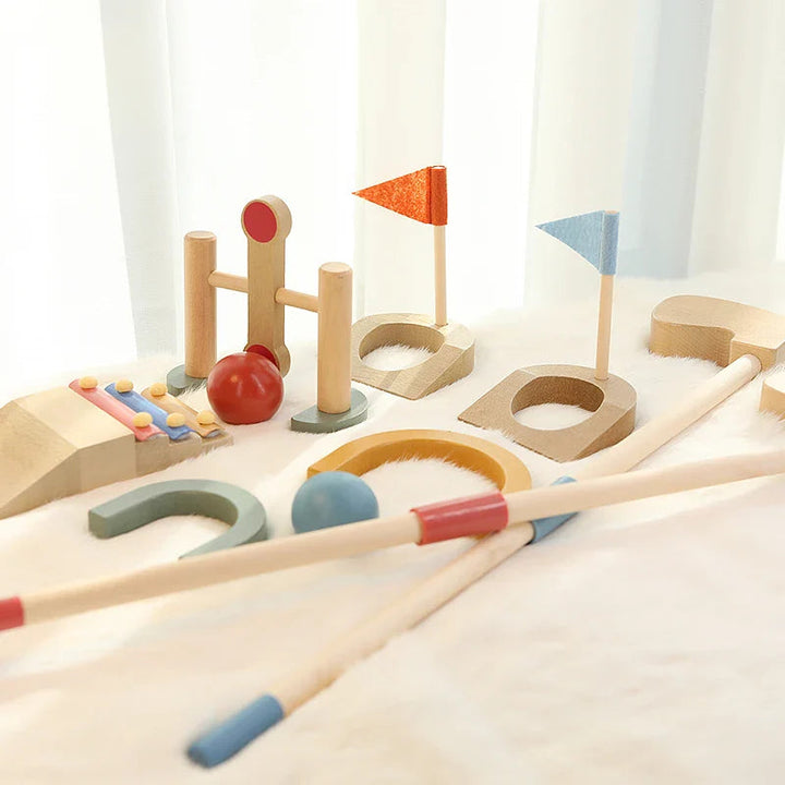 Wooden mini golf course with two flag targets, clubs, arches and red and blue balls