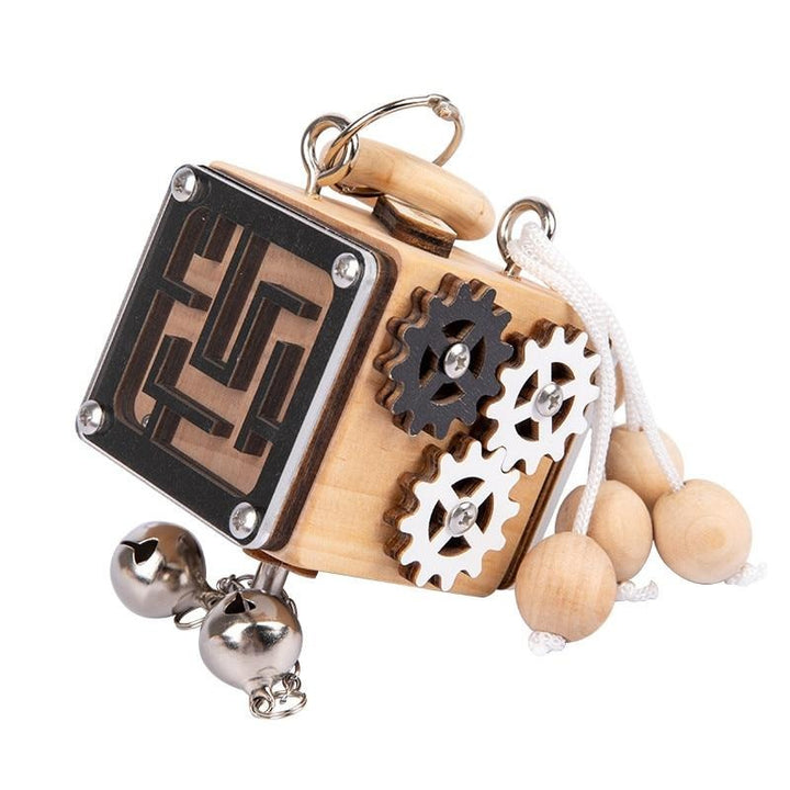 Wooden puzzle cube with a maze panel, interlocking gears, beaded cord, and bells