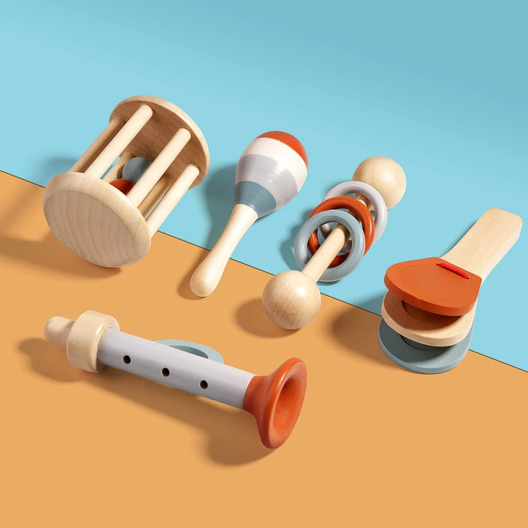 Wooden rattles, maraca, clapper and recorder-style toy arranged on a blue and yellow background