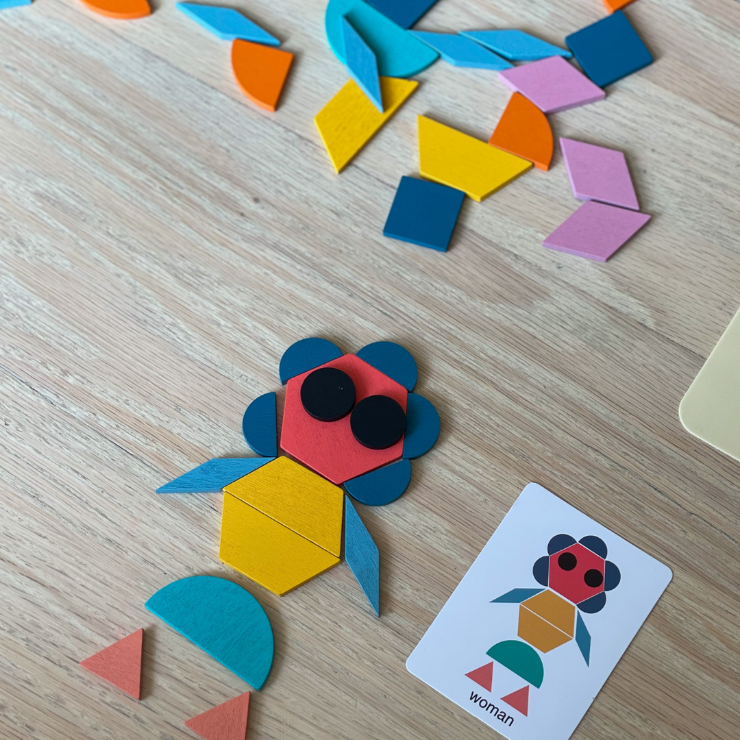 Colorful wooden shapes arranged as a fish beside the matching pattern card
