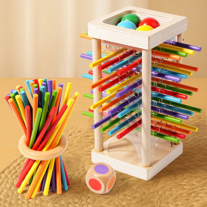Wooden stick tower with colored balls beside a balancing-stick bundle and color die.