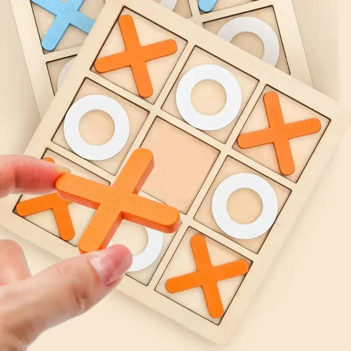 Hand holding an orange X over a wooden tic-tac-toe board with white O pieces