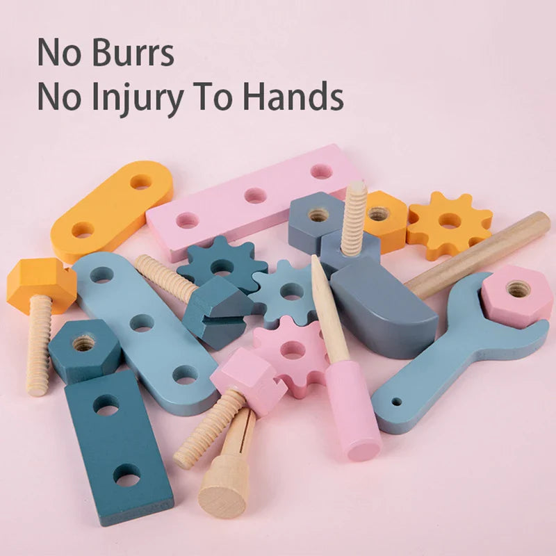Wooden hammer, wrench, screwdriver, gears, and fastening pieces arranged on a pink surface.