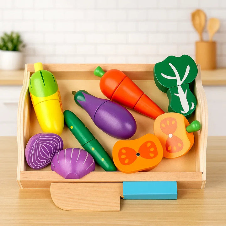 Wooden vegetable play food with corn, eggplant, carrot, and onion halves in a tray