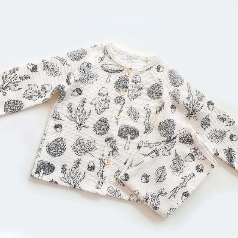 White cotton pajama top and matching pants with woodland mushroom and leaf prints