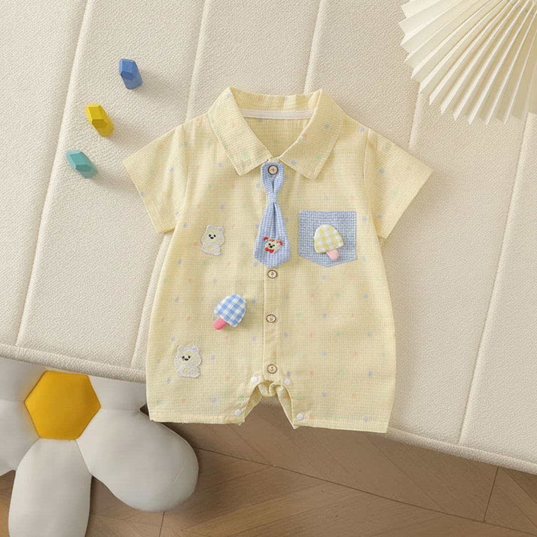 Yellow baby romper with a blue decorative tie, bear embroidery, and mushroom appliqués