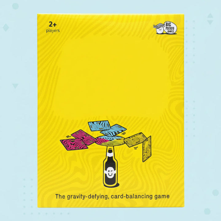 Yellow balance card game box illustrated with colorful cards balanced above a bottle.