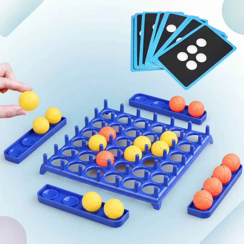 Hand holding a yellow ball beside the blue game board, ball trays, and challenge cards