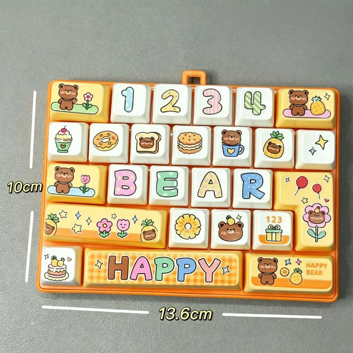 Yellow fidget keyboard with bear and food designs, labeled 13.6 by 10 cm