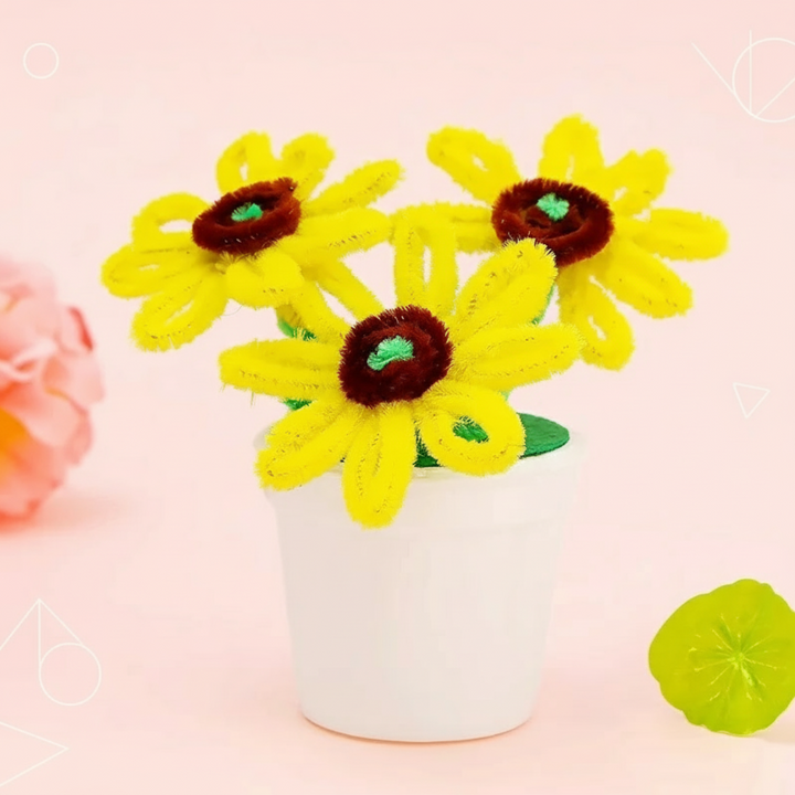 Yellow fuzzy-wire sunflowers with brown centers and green stems in a white pot