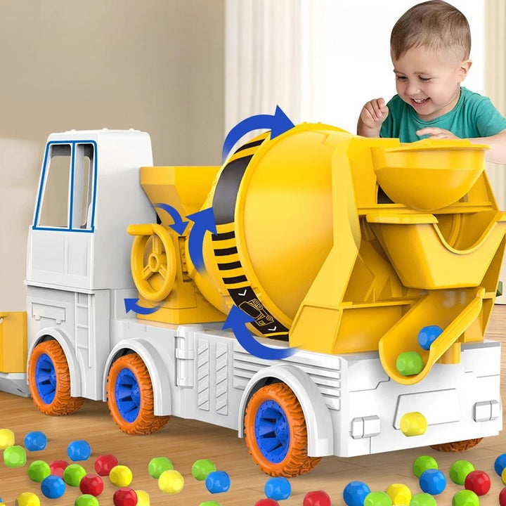 Child playing with a yellow toy cement mixer truck and colorful balls