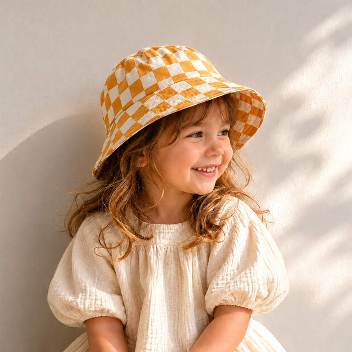 Child wearing a yellow-and-cream checkered bucket hat