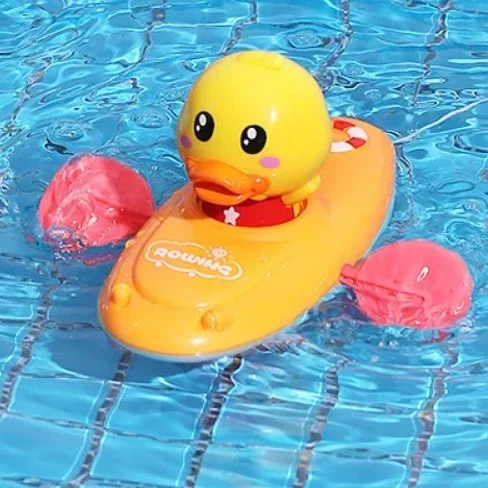 Yellow duck boat with a yellow duck and pink paddles floating in water