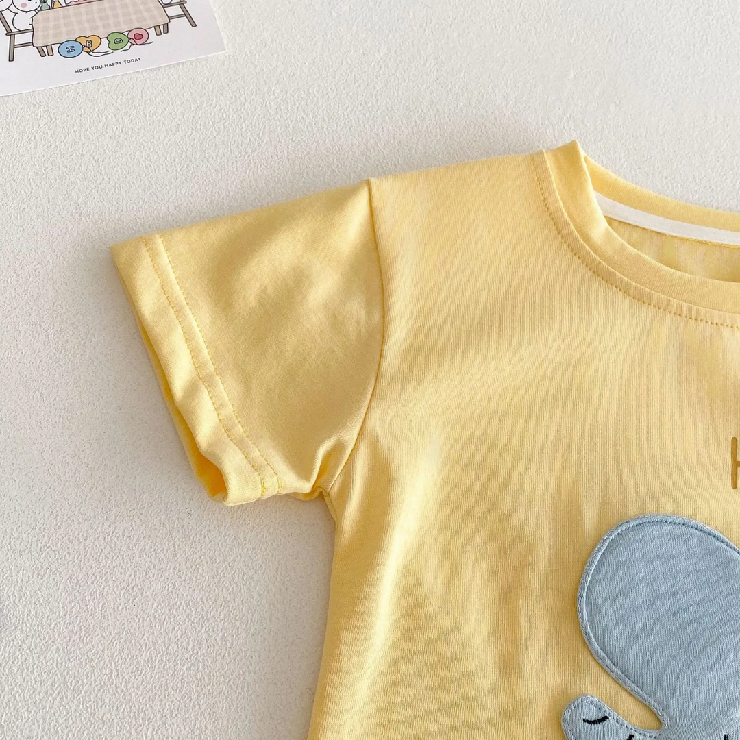 Yellow T-shirt detail showing the short sleeve, crew neckline, and part of the elephant patch
