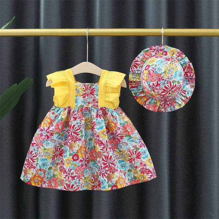 Floral baby dress with yellow ruffled straps and a matching floral hat