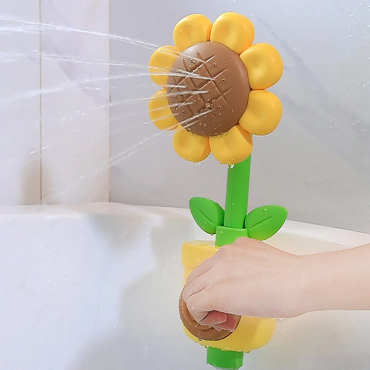 Yellow flower bath toy with a green stem spraying water as its brown front button is pressed