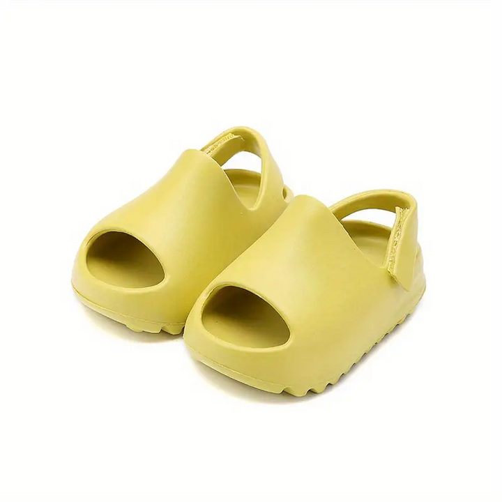 Yellow foam sandals shown at an angle with their broad uppers and heel straps visible.