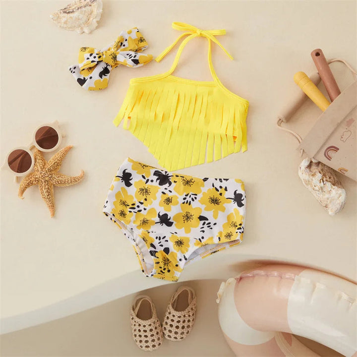 Front view of a yellow fringed bikini top, floral-print bottoms and matching bow hairband