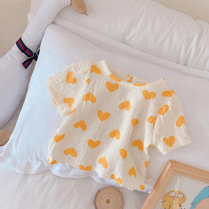 Short-sleeve cotton top with yellow hearts and a rounded neckline