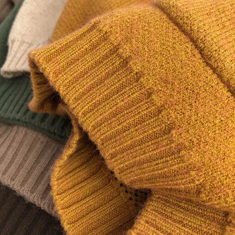 Close-up of a yellow sweater sleeve showing the knit texture and ribbed cuff