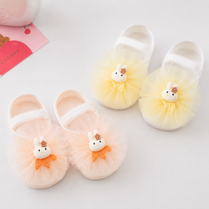 Yellow and pale orange baby socks with bunny accents and ruffled fronts