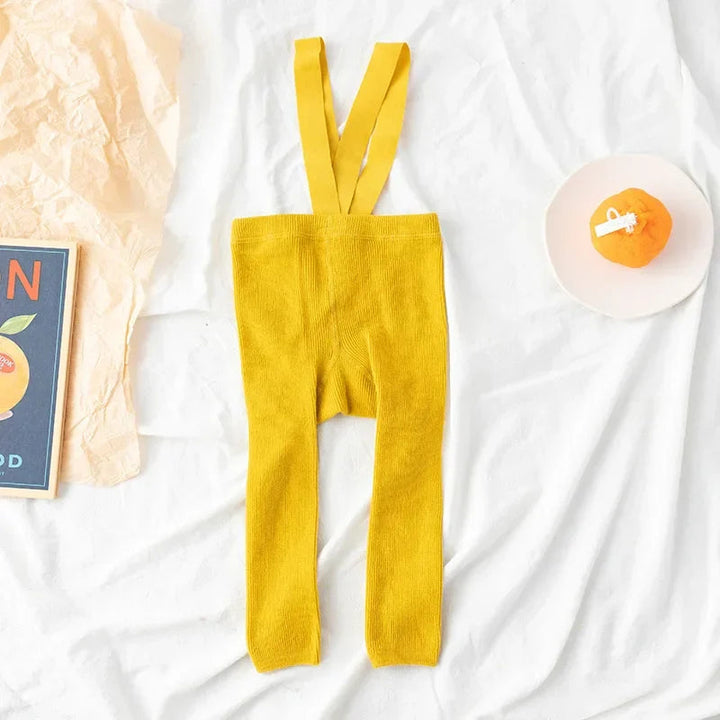 Yellow ribbed baby leggings with matching suspenders laid flat