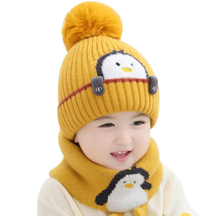 Close view of a child wearing a yellow ribbed penguin hat and matching scarf